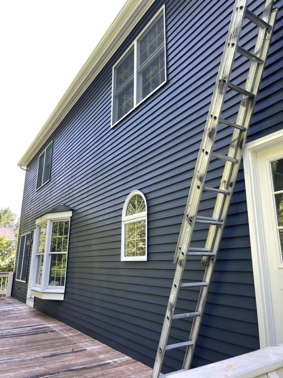 A Ladder is Leaning Against the Side of a House — North Hampton, NH — MG Painting And Hardwood Floor