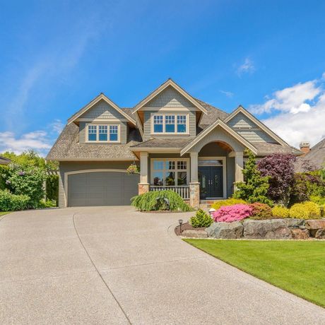 A large house with a concrete driveway leading to it