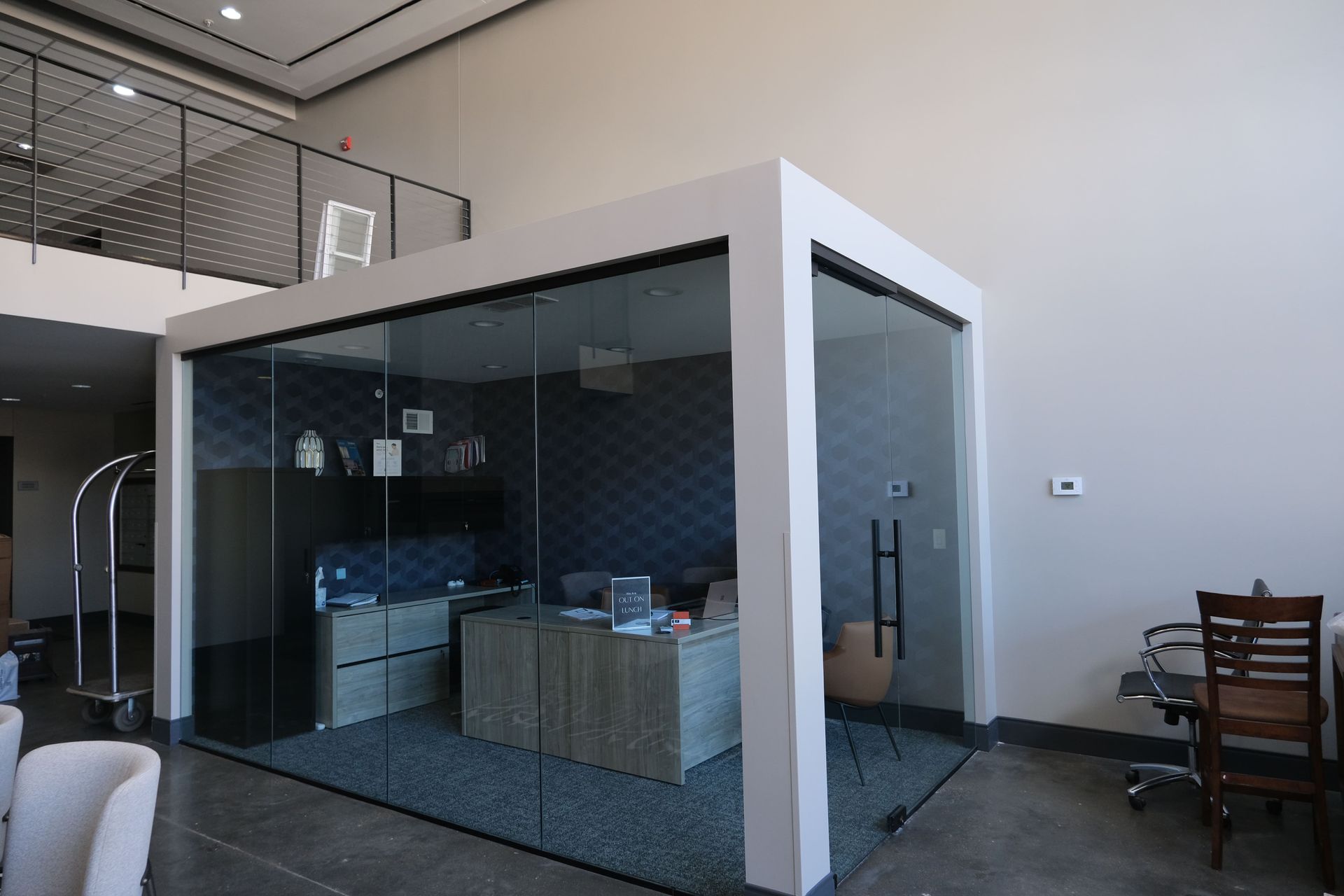 A glass room with a desk and chairs inside of it