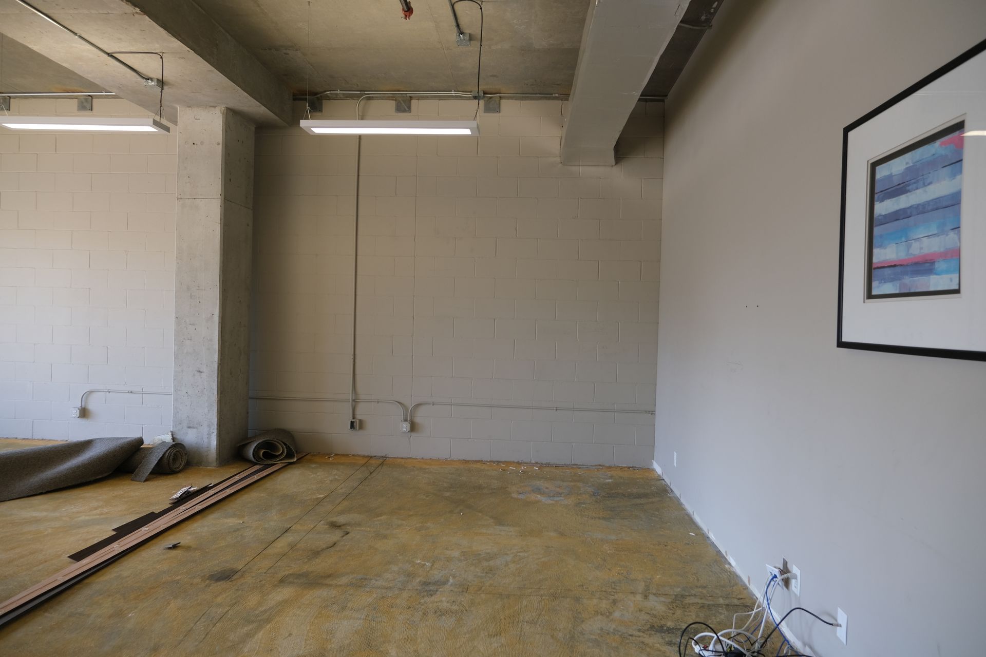An empty room with a picture on the wall.