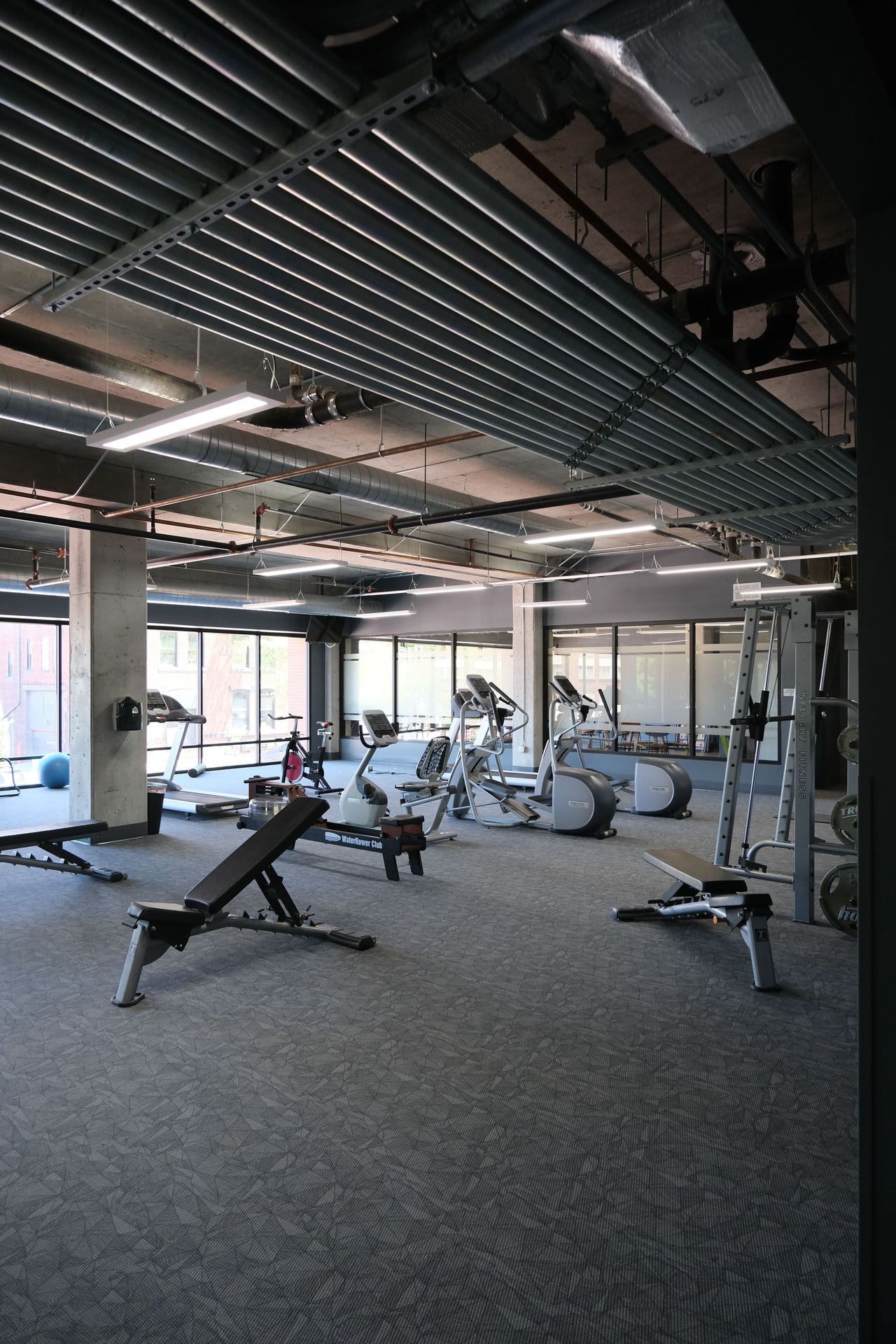 A large gym filled with lots of exercise equipment.