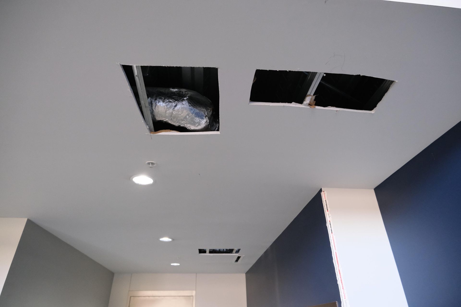 A white ceiling with two holes in it