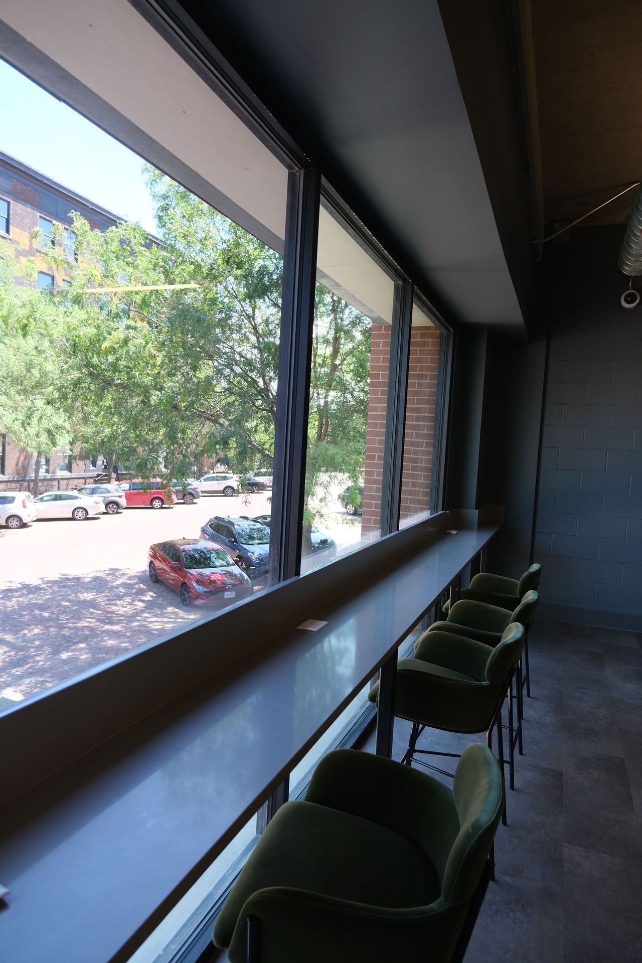 A row of chairs sitting in front of a window with a view of a street.