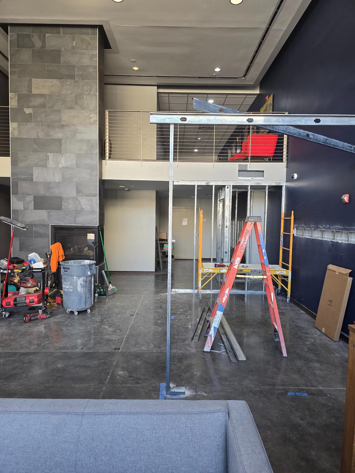 A room with a couch and a ladder in it