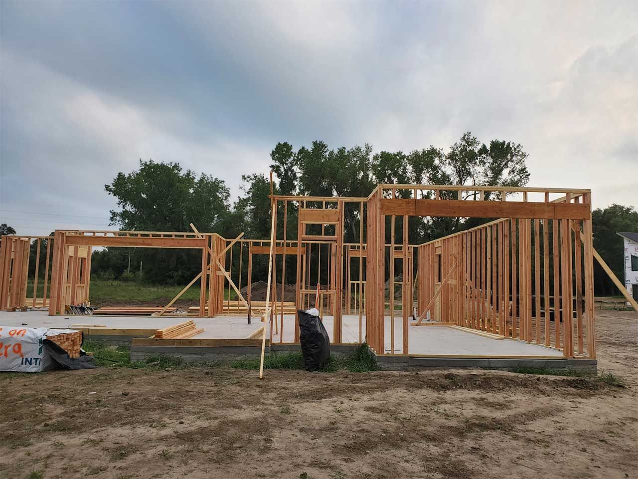 A house is being built in the middle of a dirt field.