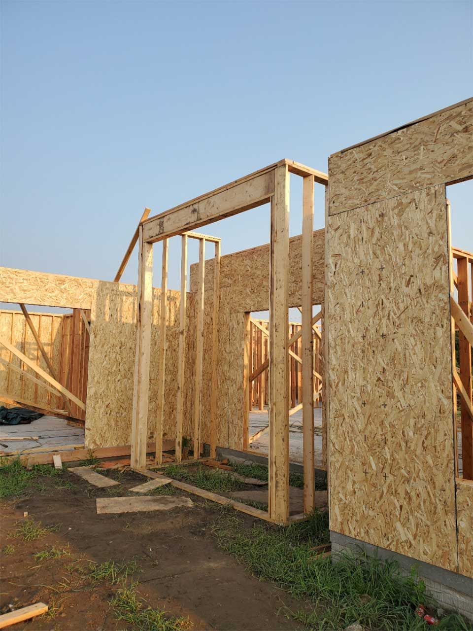 A house is being built with a blue sky in the background