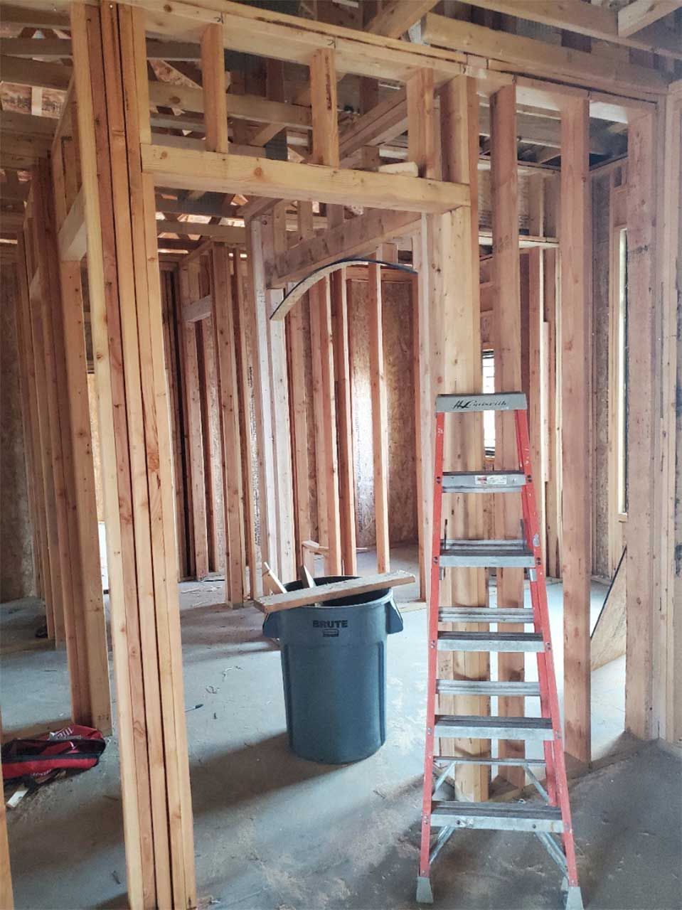 A ladder is sitting in the middle of a room under construction