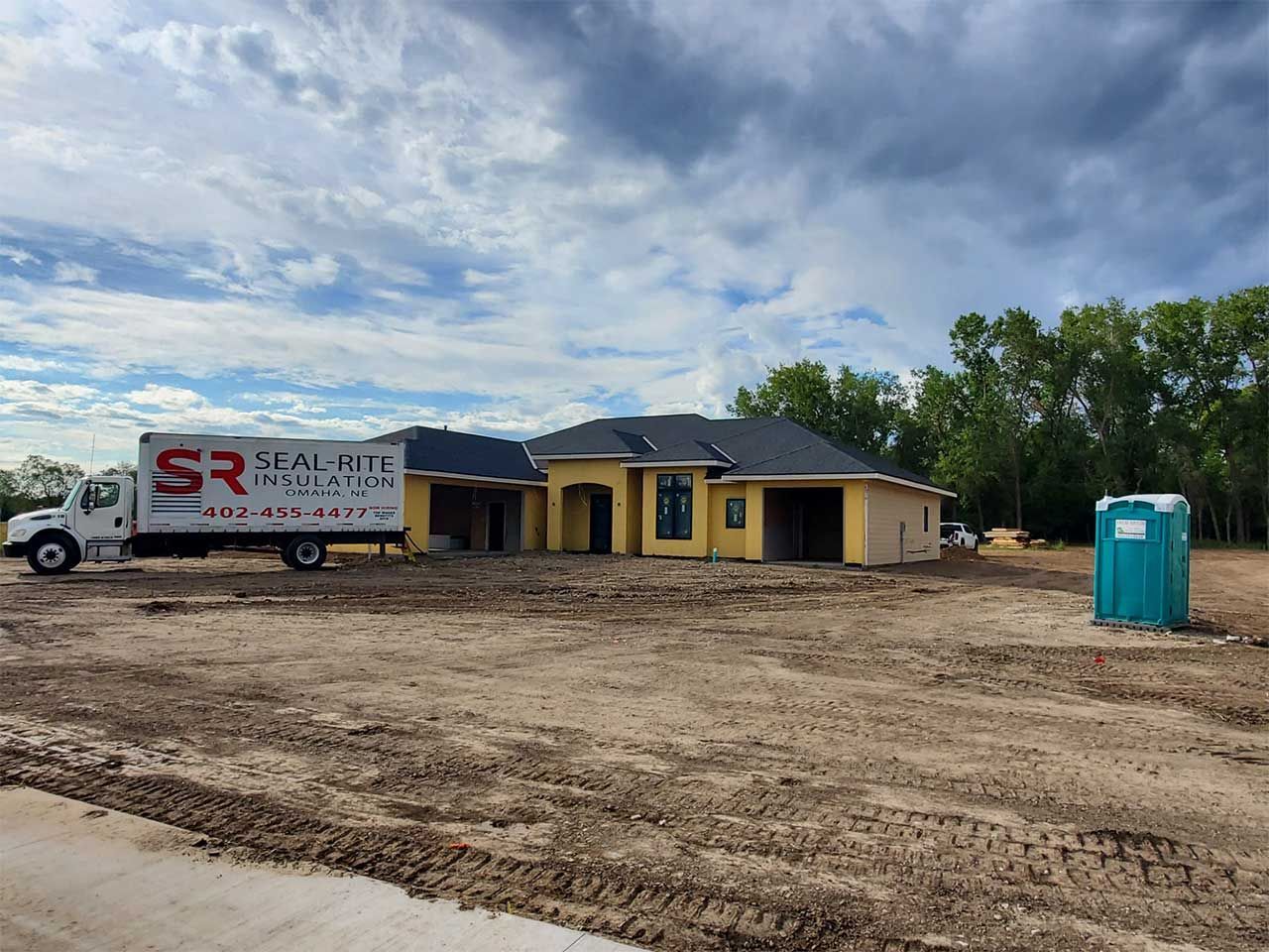 A truck is parked in front of a house under construction.