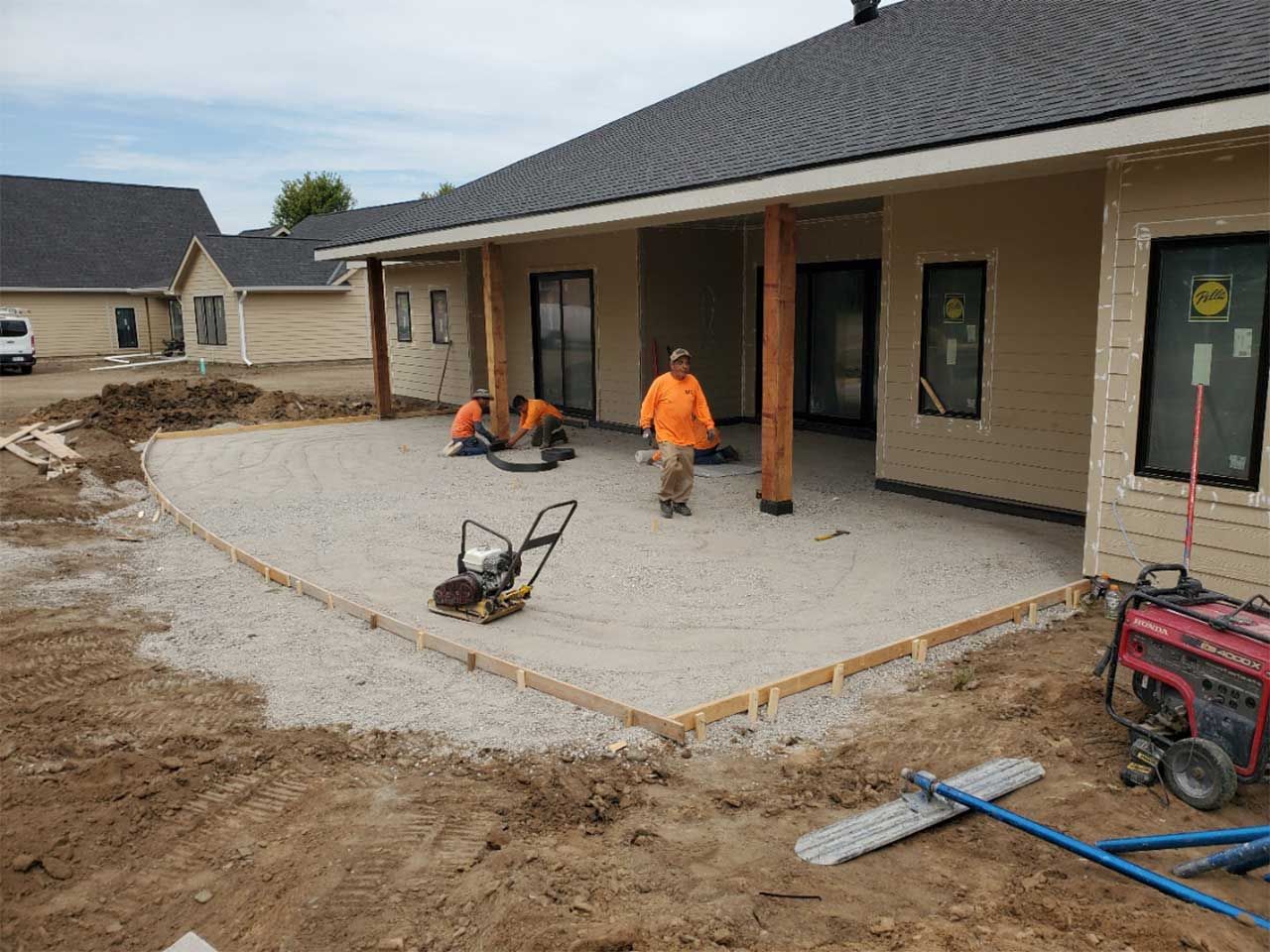 A man is standing on a patio in front of a house.
