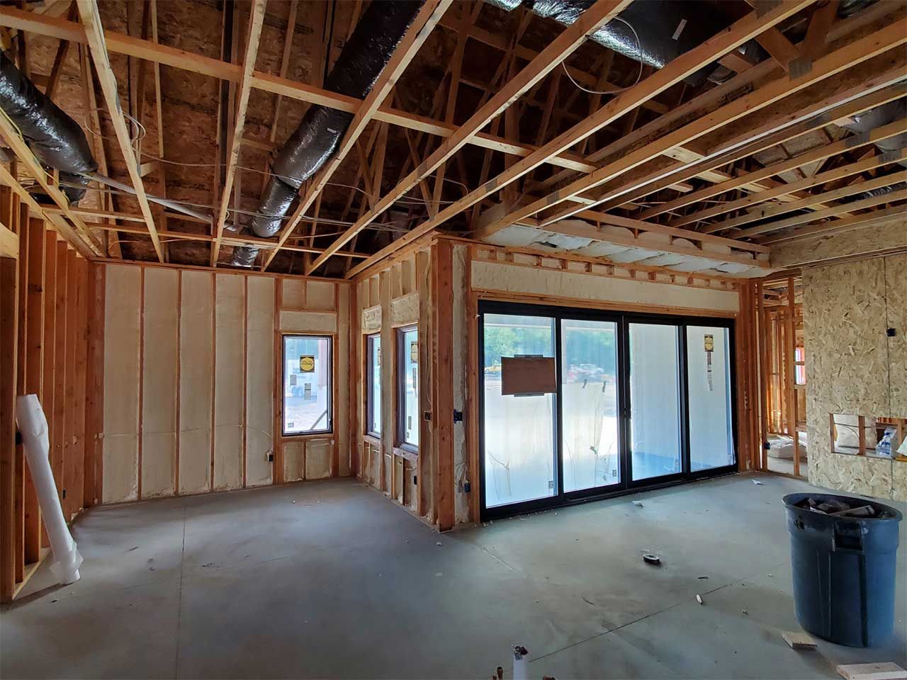 A room in a house under construction with sliding glass doors.