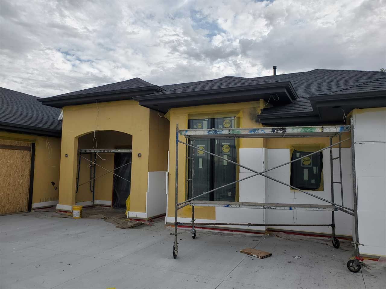 A house under construction with a scaffolding in front of it.