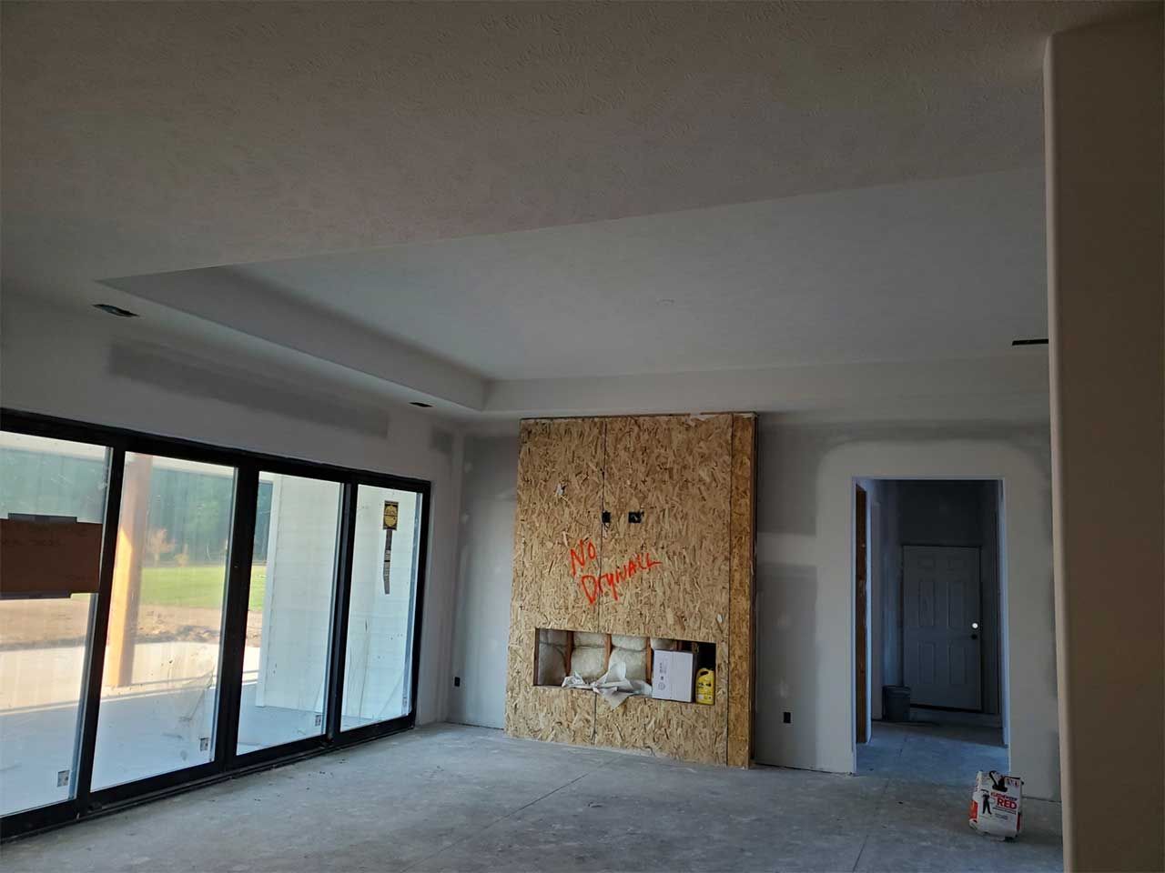 A large empty room with a fireplace and a lot of windows.