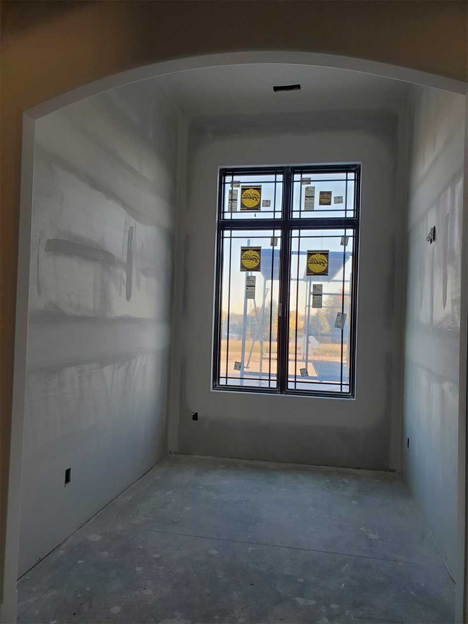 An empty room with a large window in the middle of it.