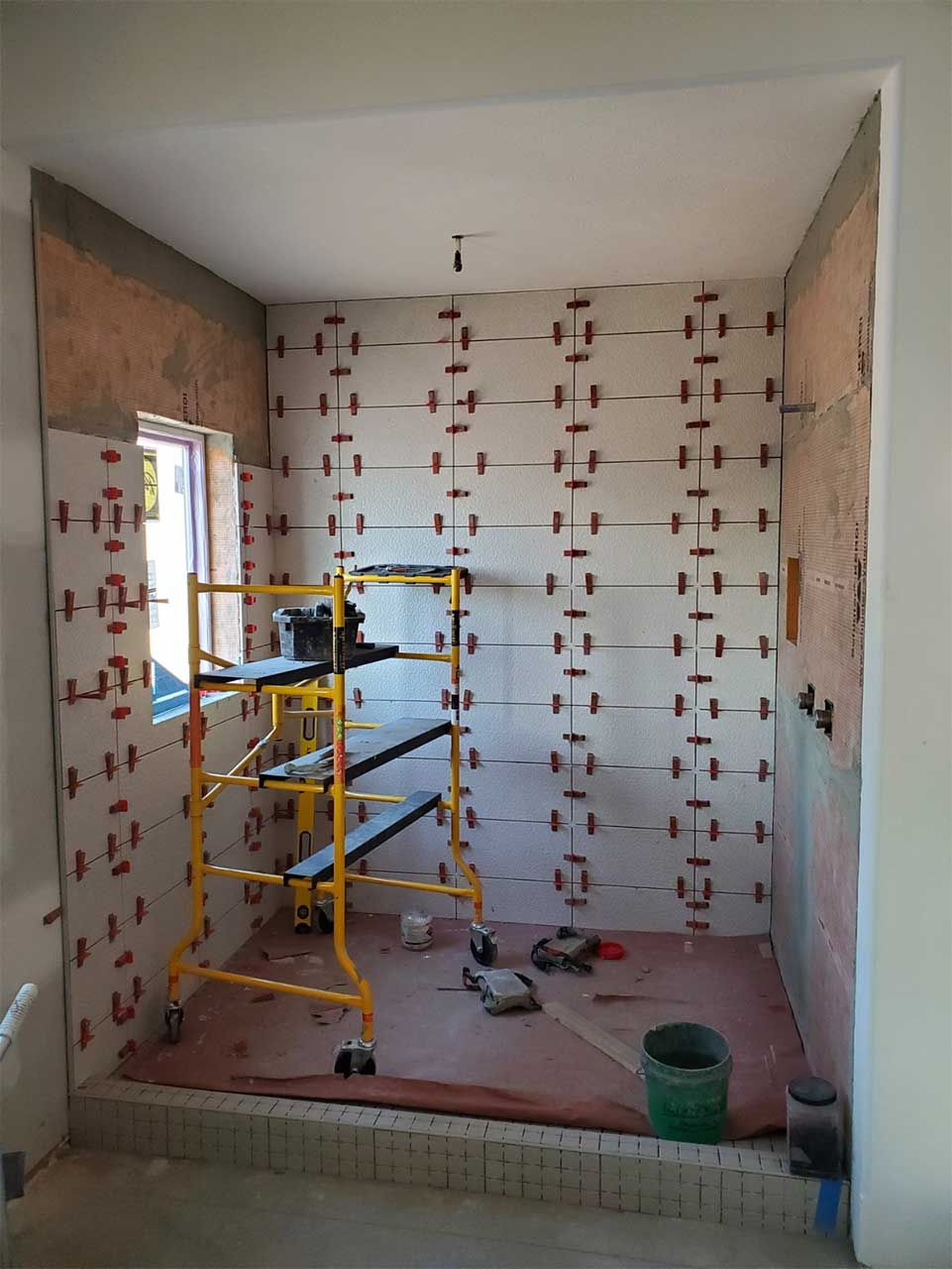 A room under construction with a scaffolding and a window