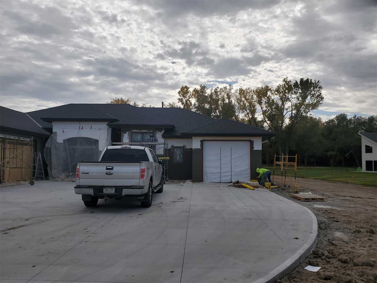 A truck is parked in front of a house under construction.