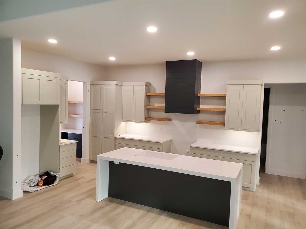A kitchen with white cabinets and a large island in the middle.