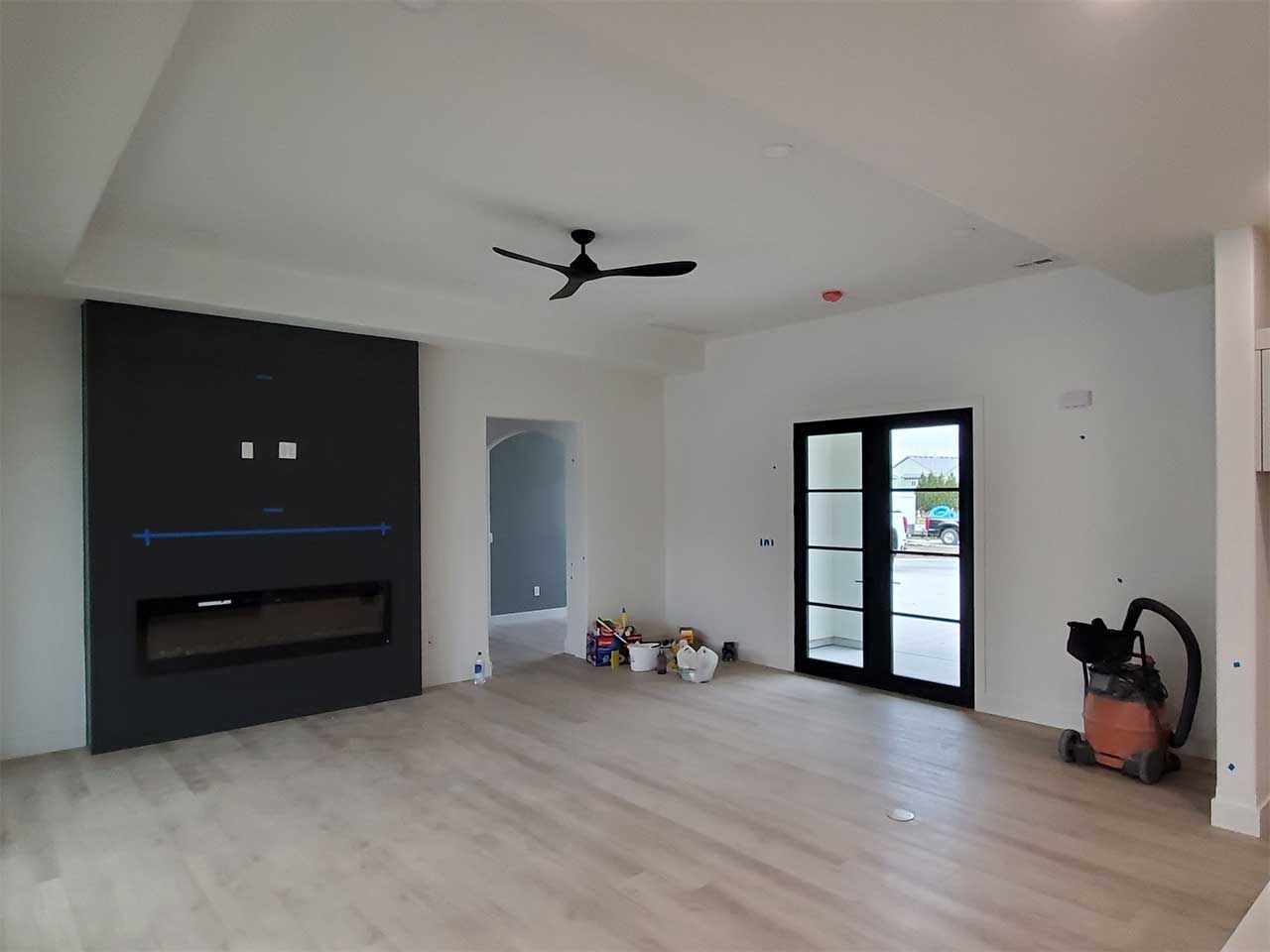 A living room with a fireplace and a ceiling fan