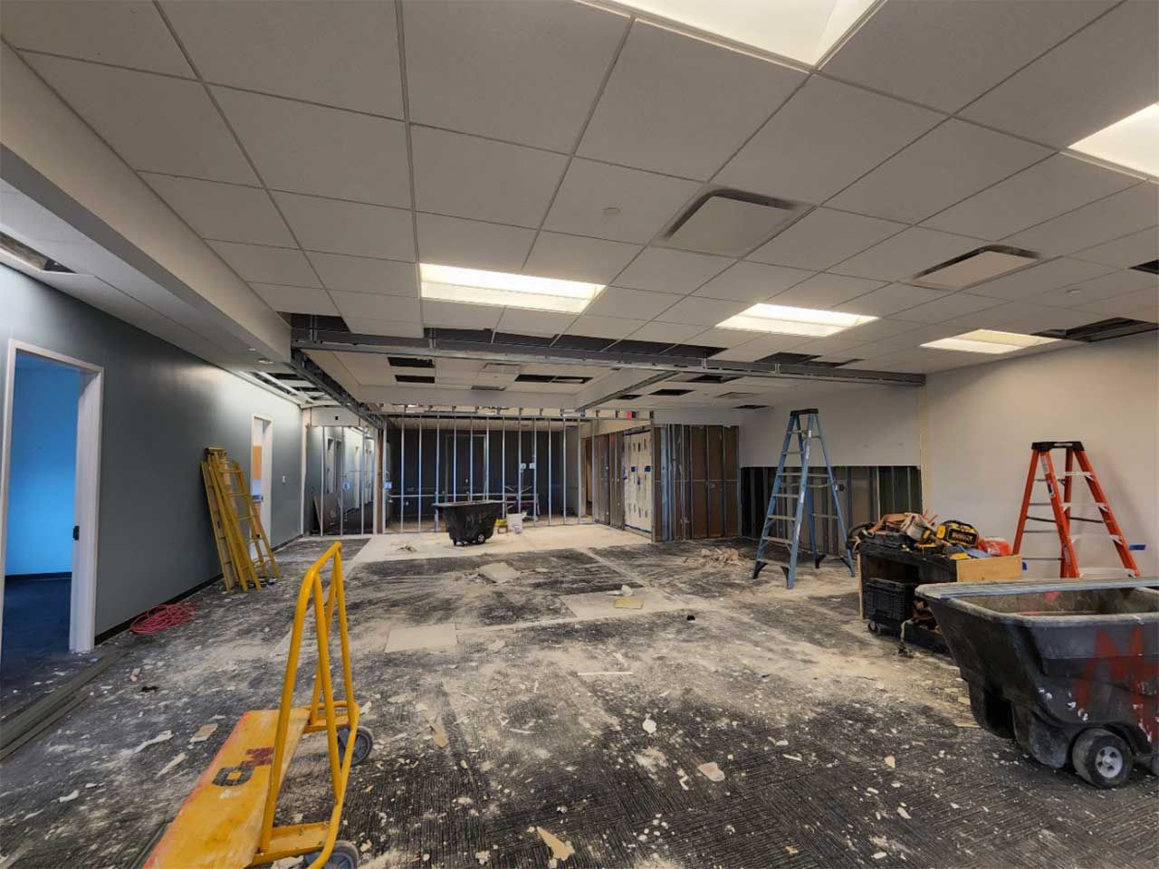 A large room that is being remodeled with a ladder on the floor.