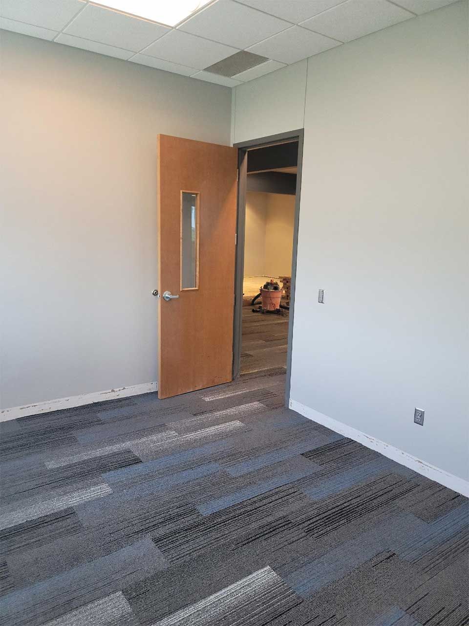 An empty room with a door and a window.