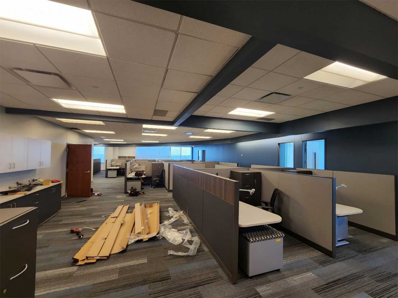 A large empty office with cubicles and a kitchen.