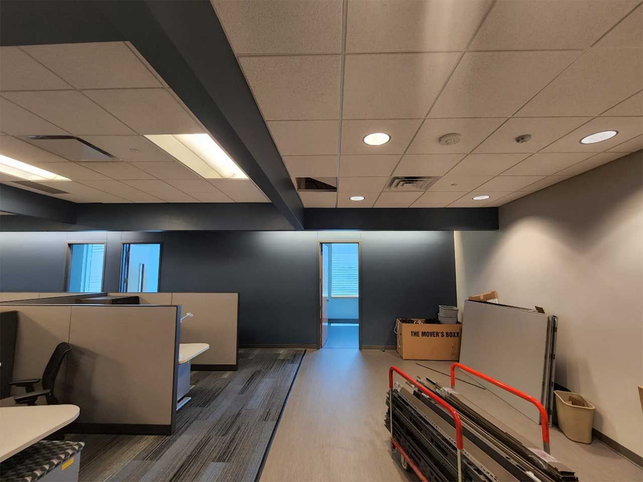 An empty office with cubicles and a white board on the floor.