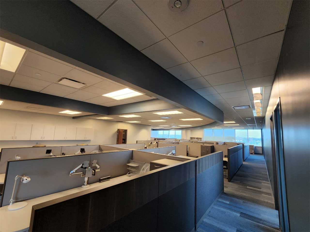 A large office with a lot of cubicles and a hallway.