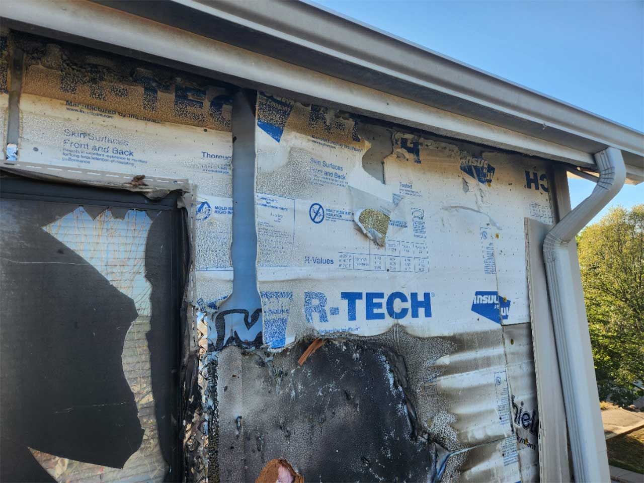 A person is working on the side of a house.