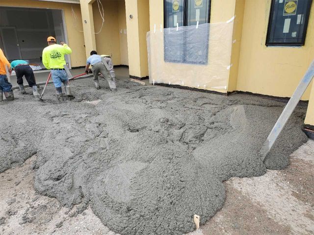A large pile of concrete is being poured on the ground