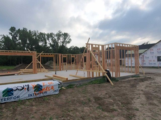 A house is being built in the middle of a dirt field.