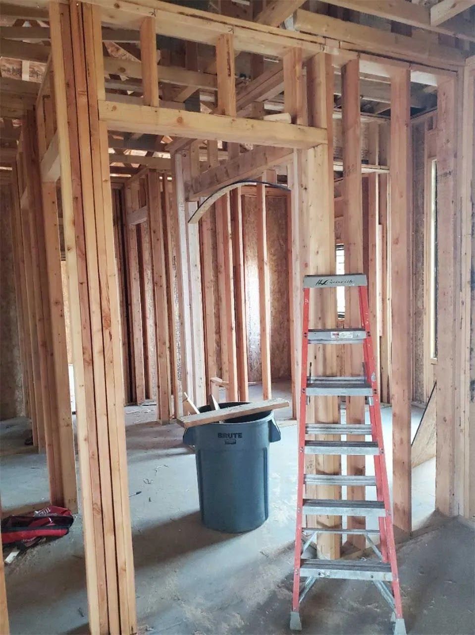 A ladder is sitting in the middle of a room under construction
