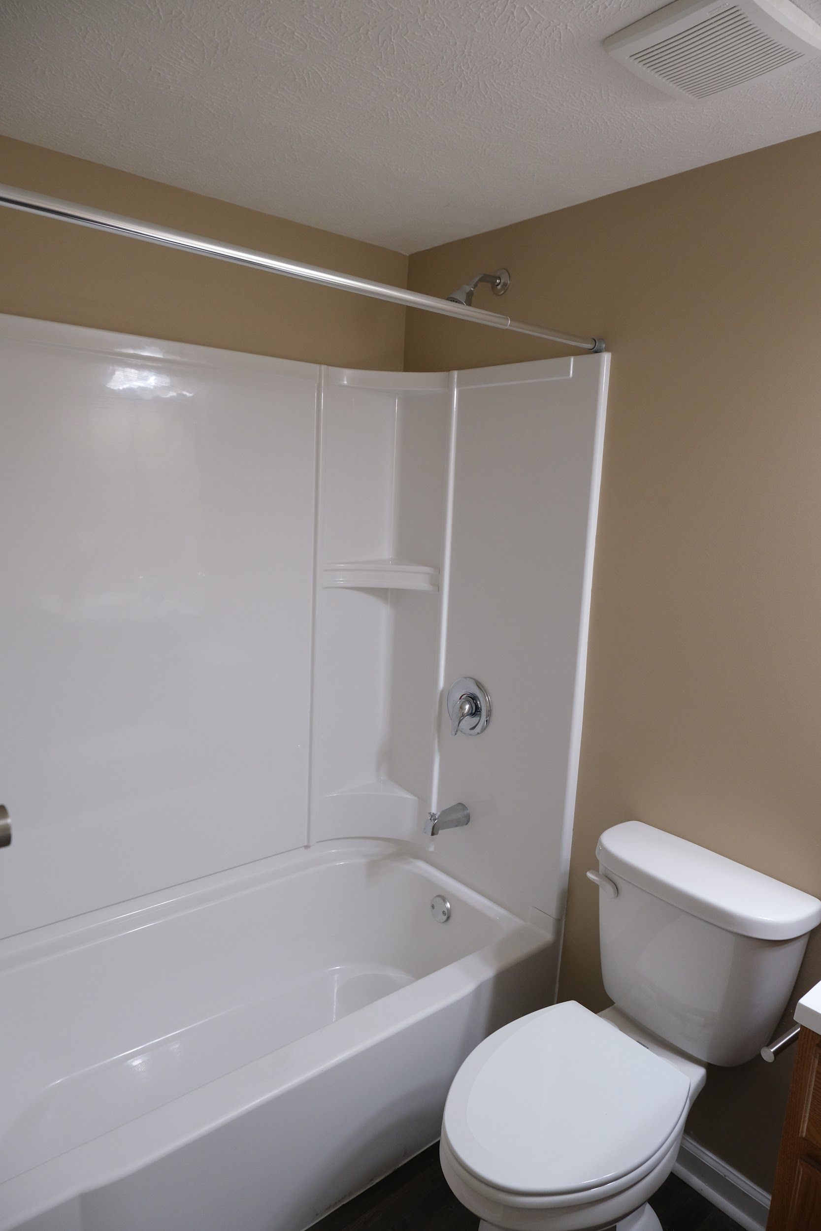 A bathroom with a toilet , bathtub and shower.