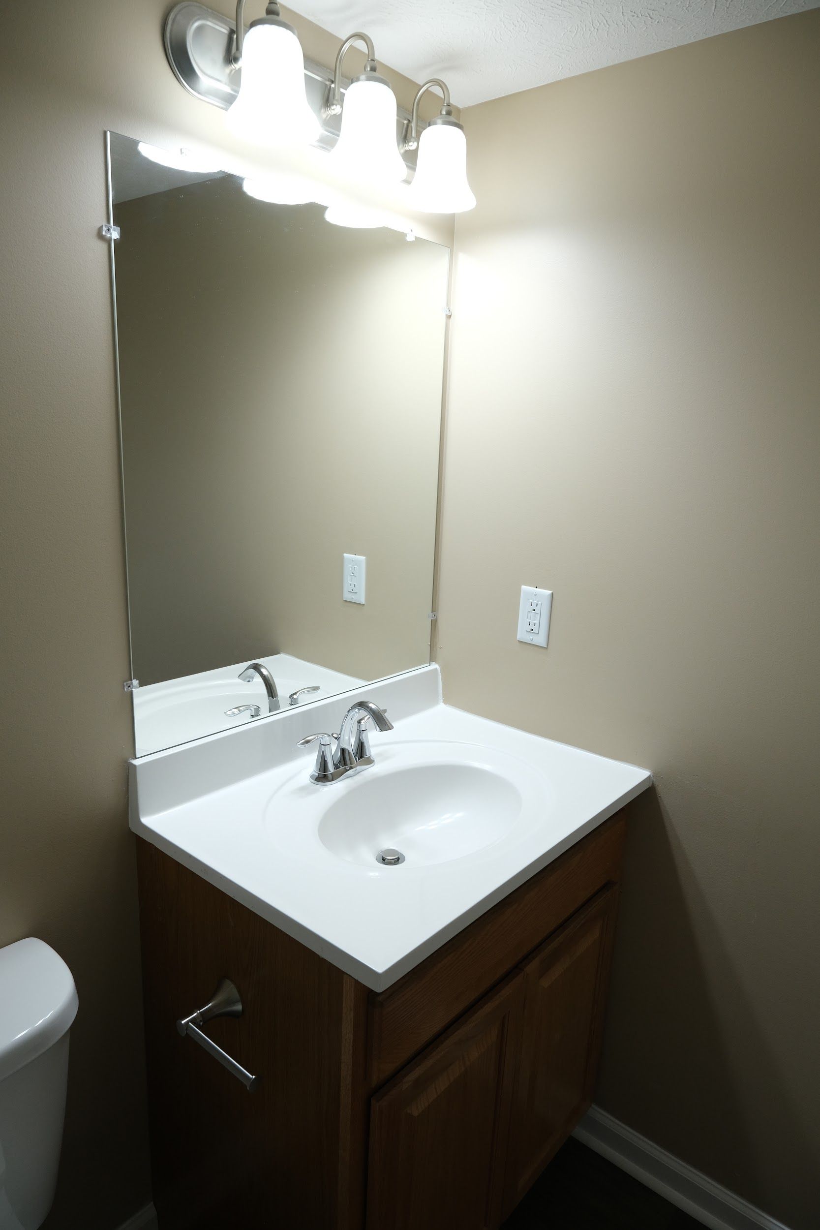 A bathroom with a sink a toilet and a mirror