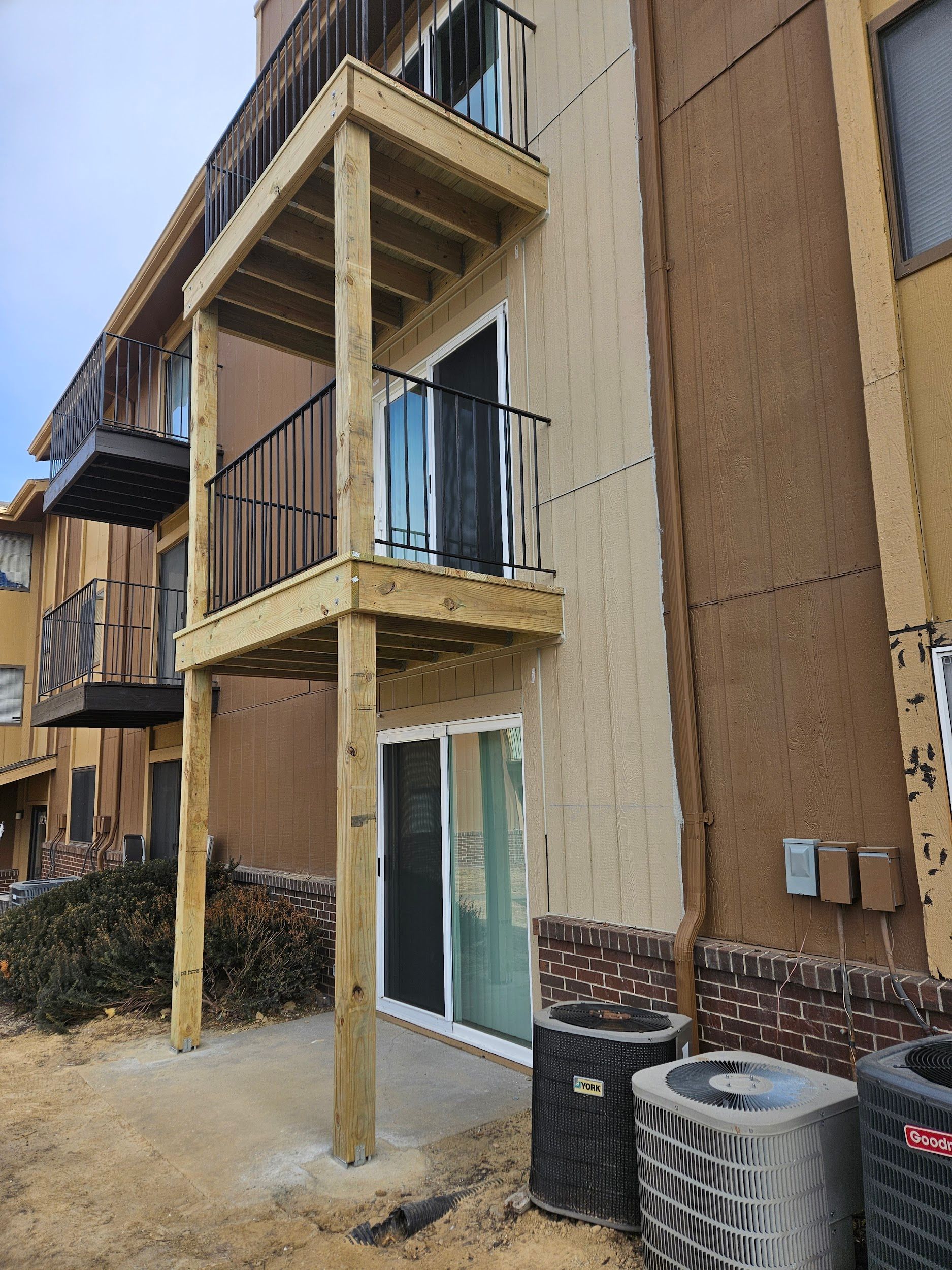 A building with a balcony and air conditioners on the side of it.