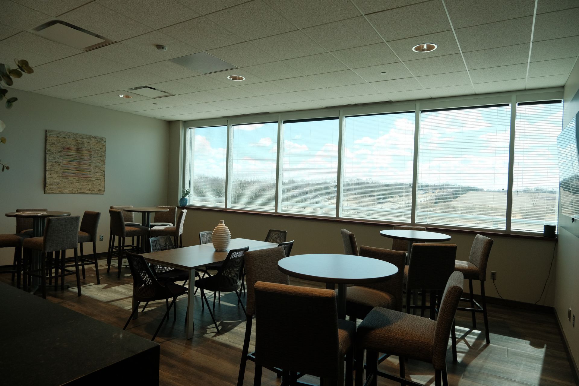 A dining room with tables and chairs and a large window