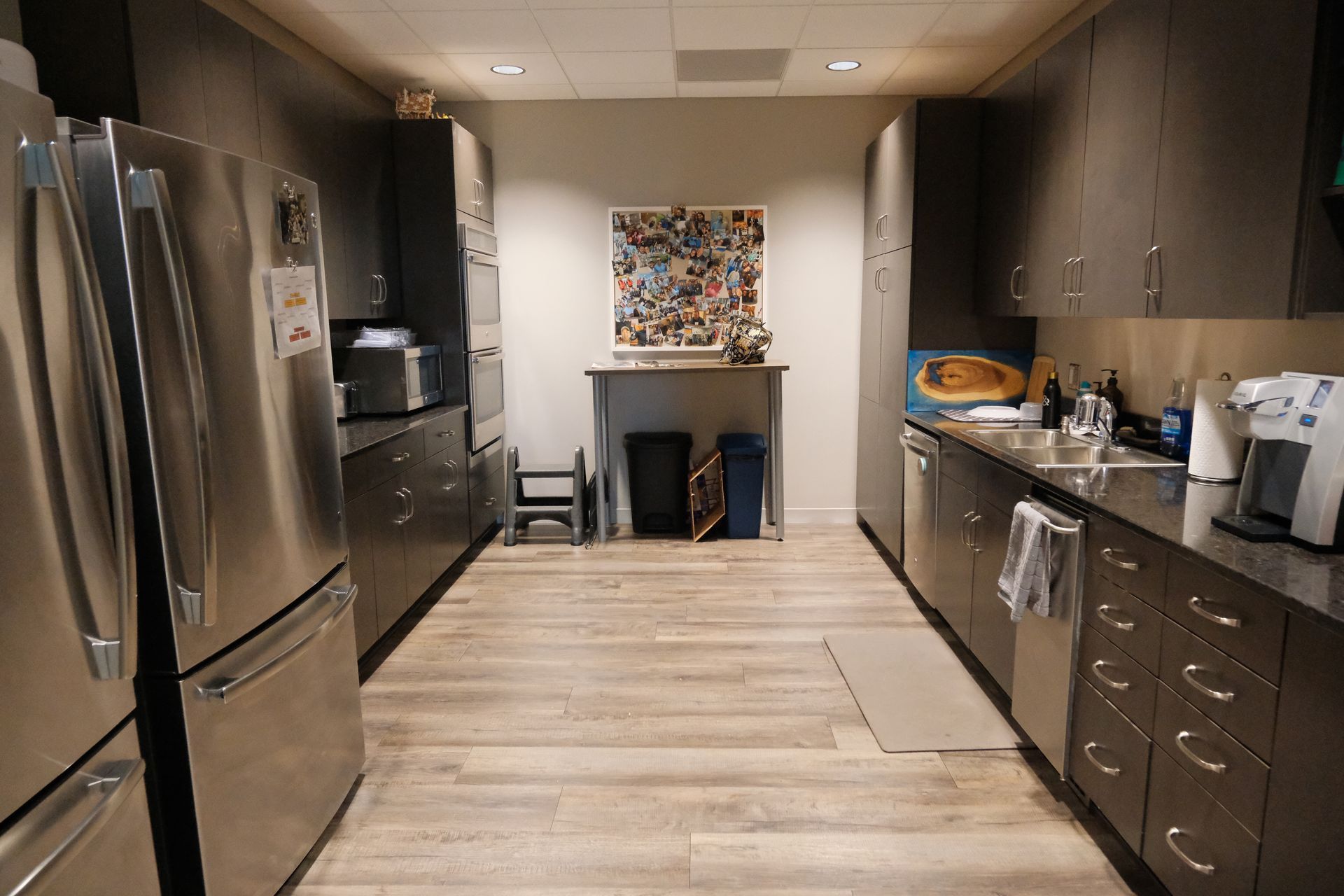 A kitchen with stainless steel appliances and wooden floors.