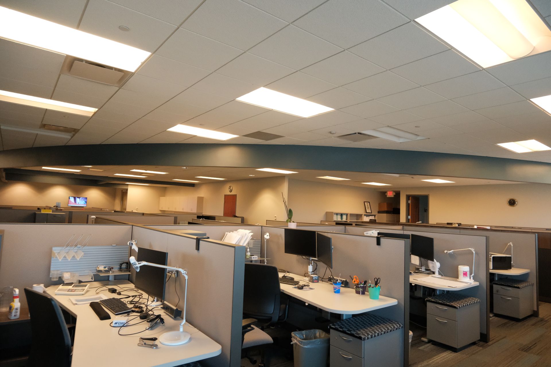 A large office with cubicles and desks filled with computers.
