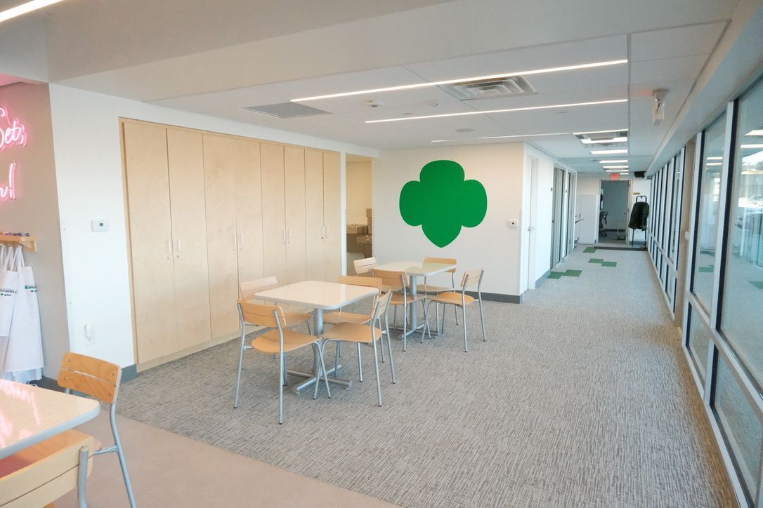 A hallway with tables and chairs and a green clover on the wall
