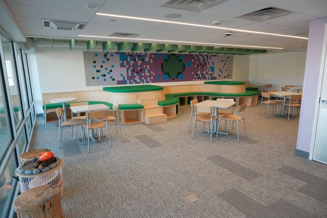 A room with tables and chairs and a painting on the wall