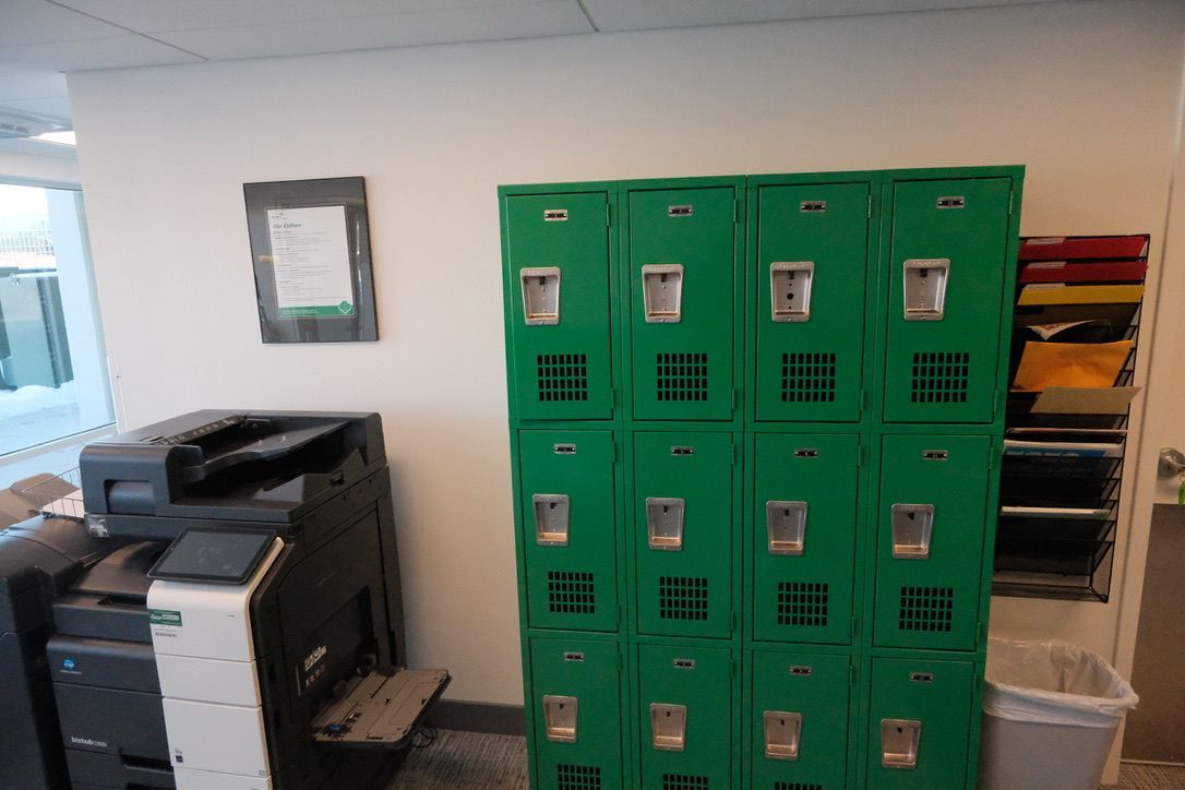 A row of green lockers next to a printer