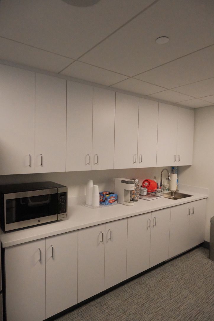 A kitchen with white cabinets and a microwave