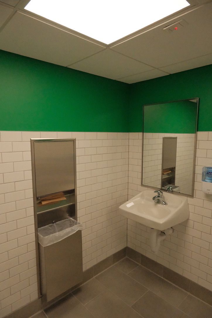 A bathroom with green walls and a sink