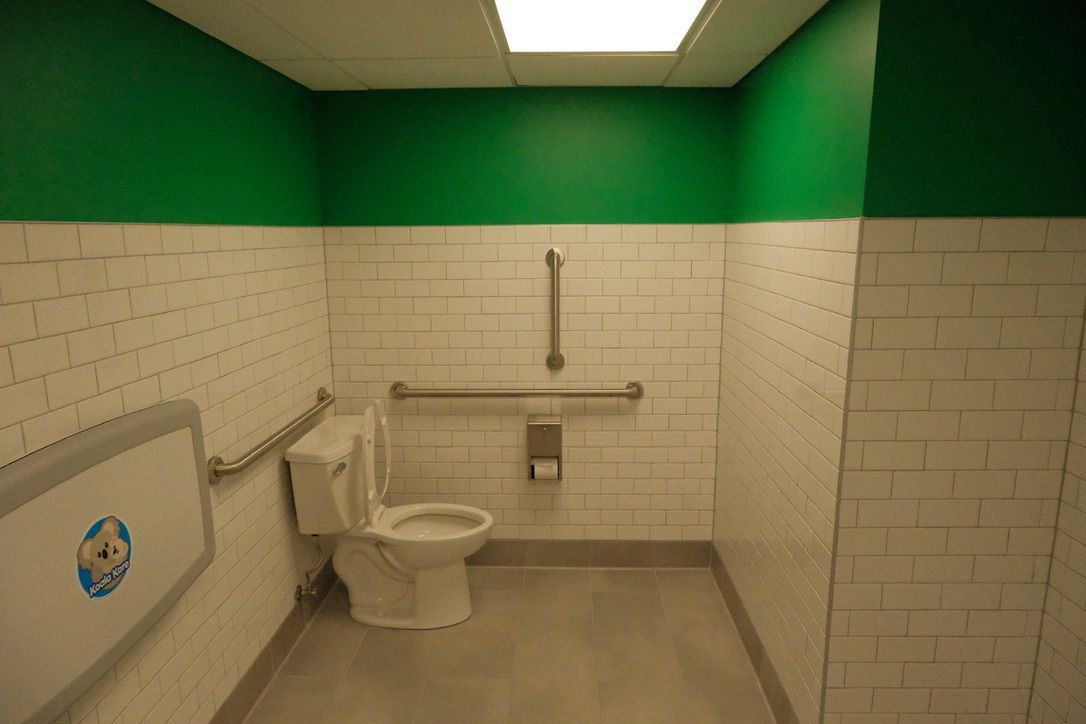 A bathroom with a toilet and green walls