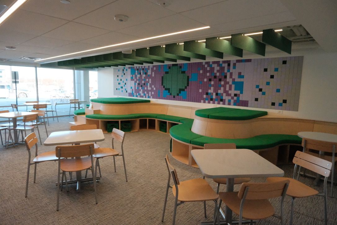 A room with tables and chairs and a painting on the wall