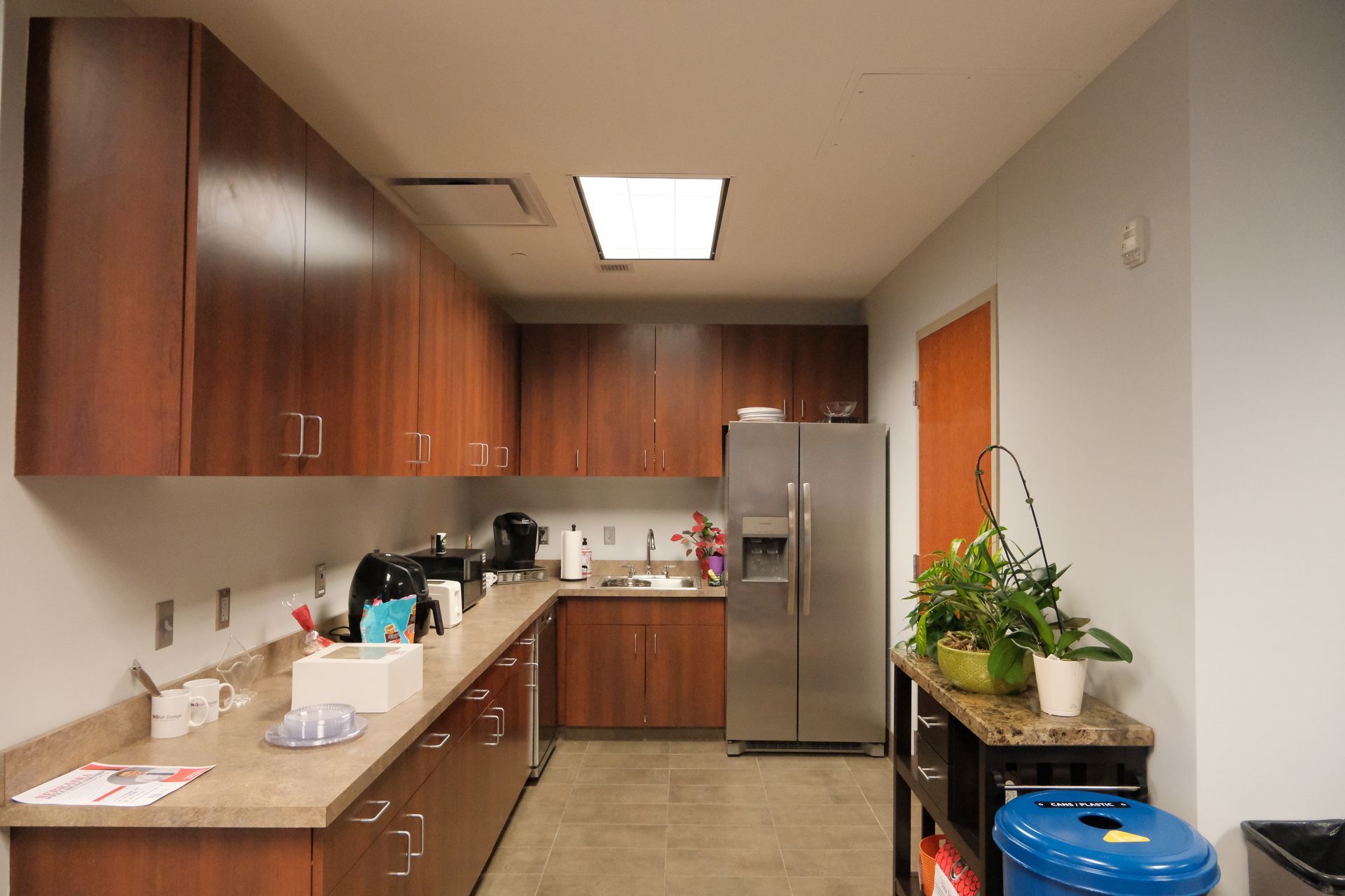 A kitchen with wooden cabinets and a stainless steel refrigerator