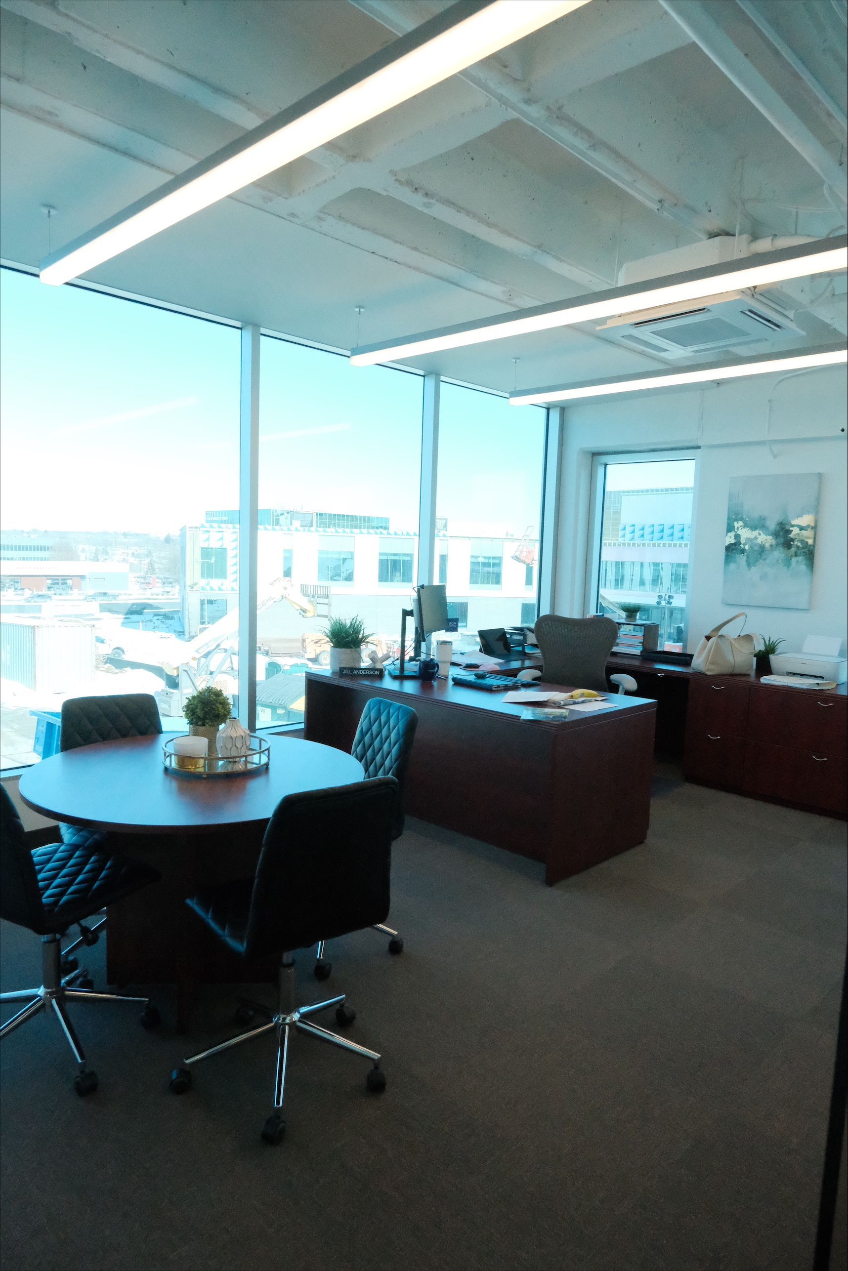 A conference room with a table and chairs and a large window