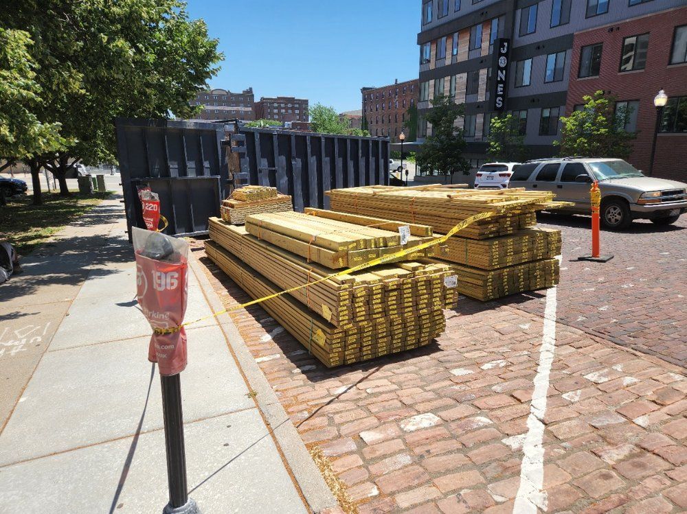 A pile of wood is sitting on the side of the road.