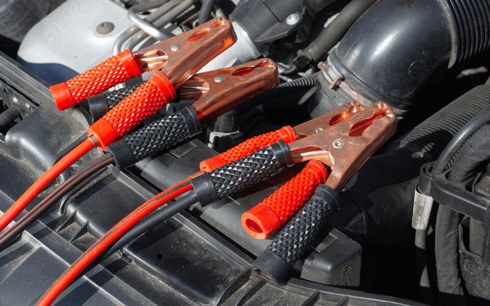 a mechanic using spark plugs to start a car