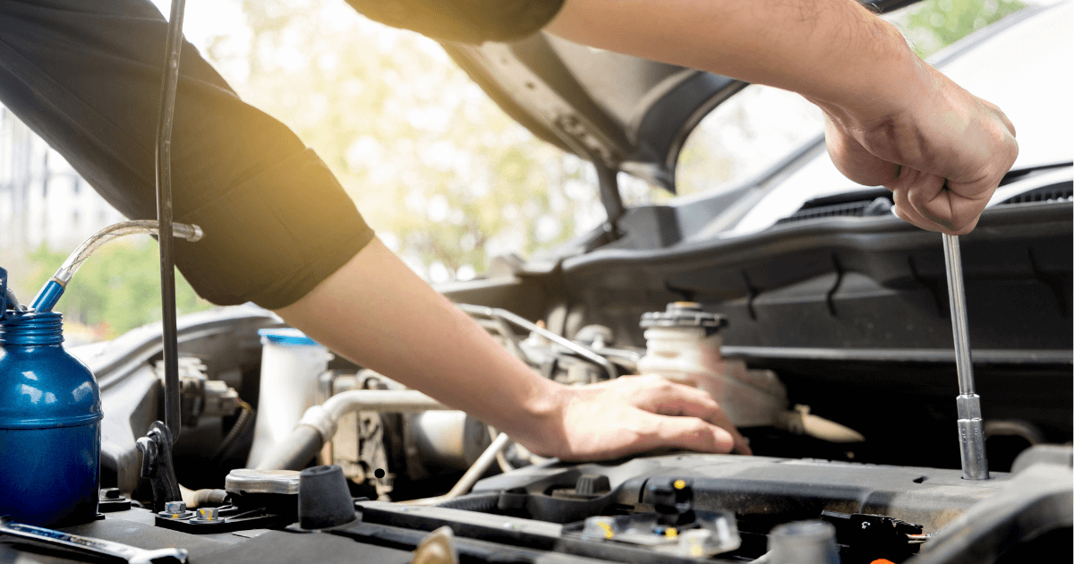 a mechanics doing outdoor auto repair with the sun shining