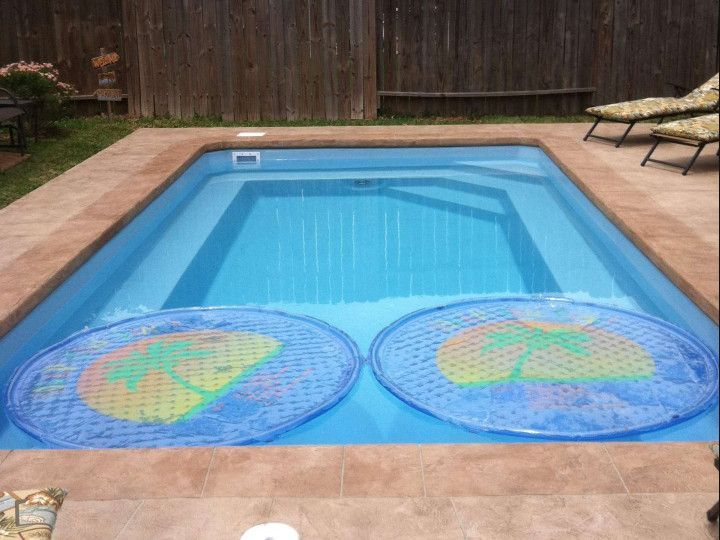 A swimming pool with a wooden fence in the background