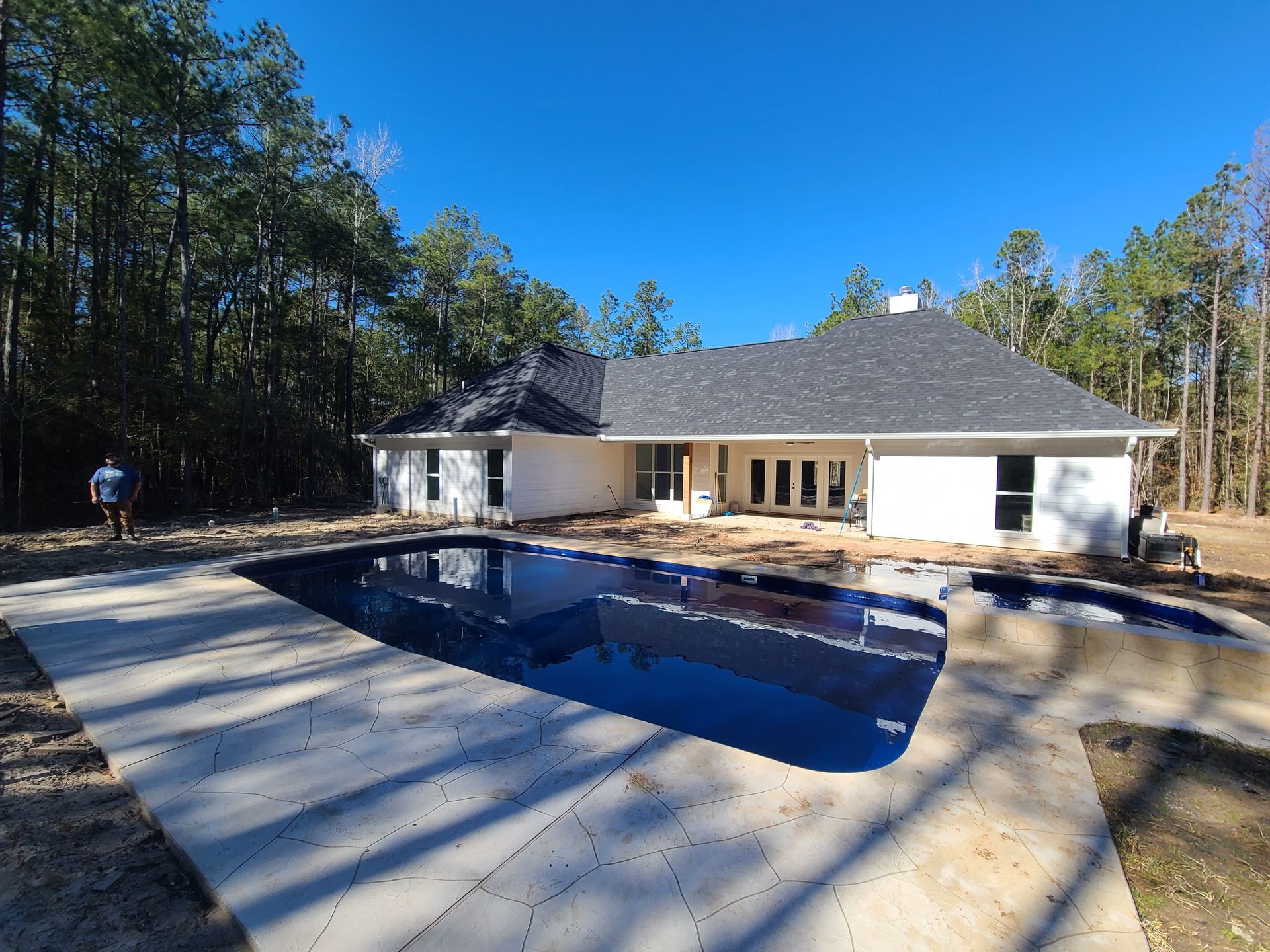 A house with a large swimming pool in front of it